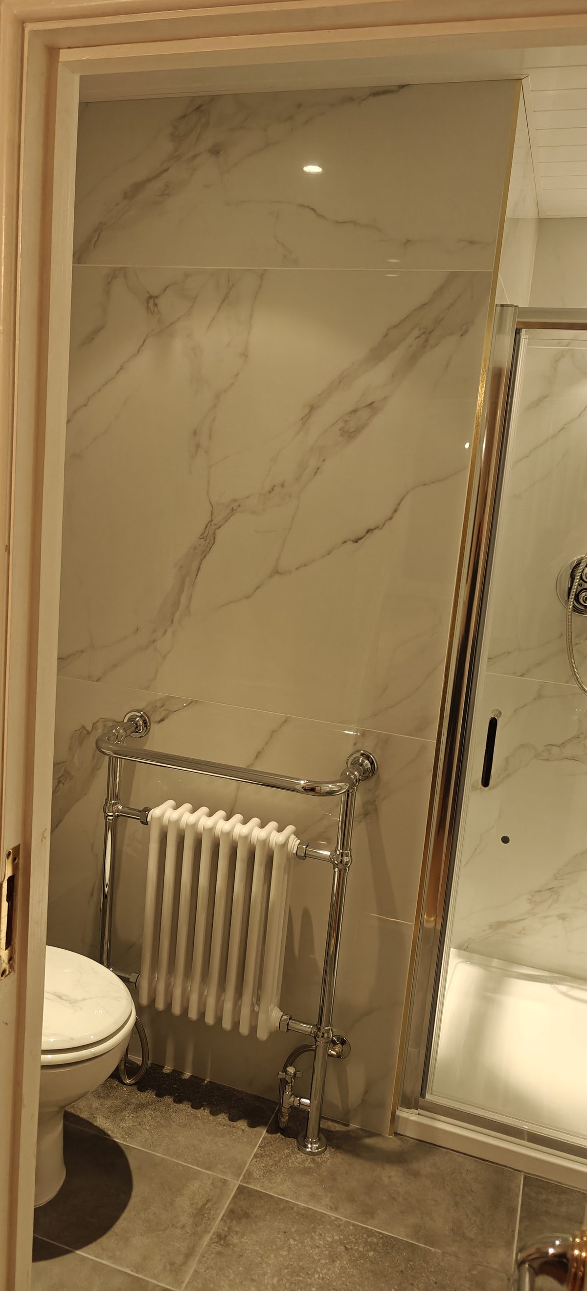 Finished marble effect bathroom with brass trimmed shower screen