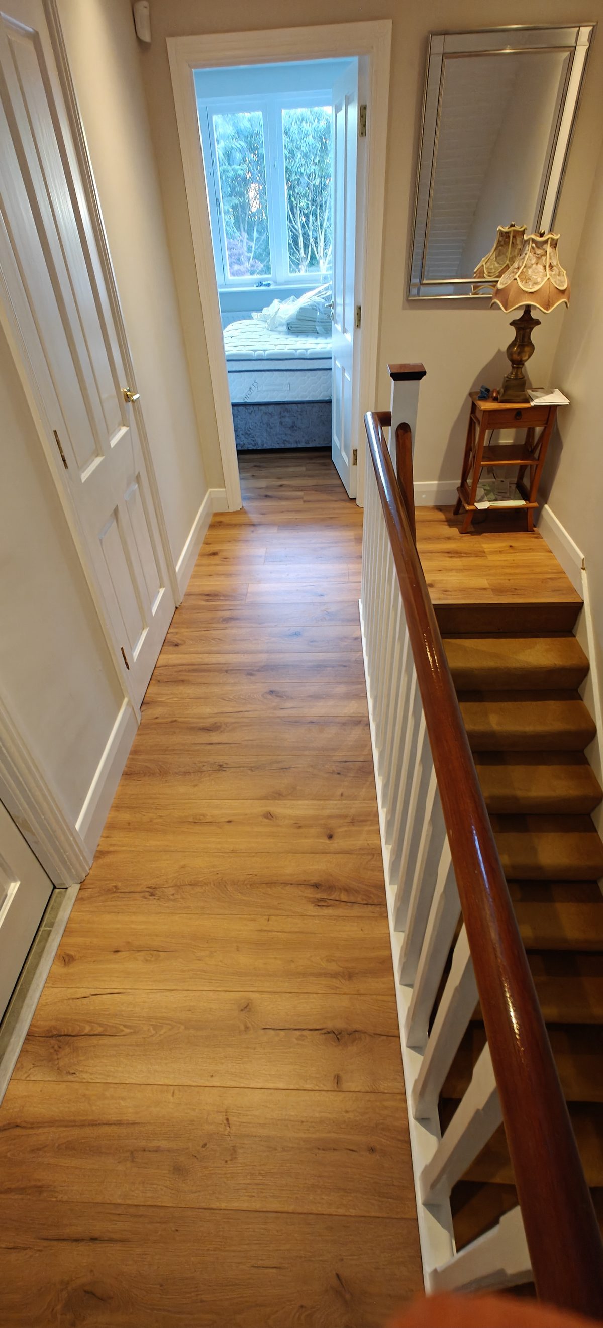 Oak flooring laid through a hallway and up the stairs in a renovated house